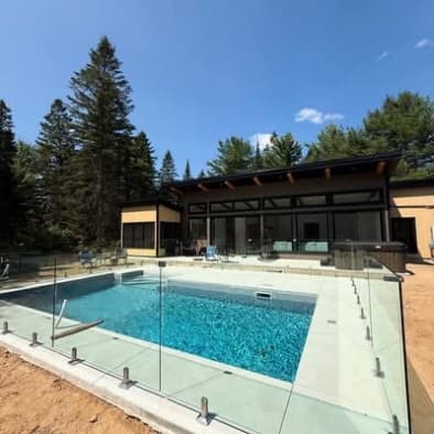 Clôture de piscine avec terrasse en pierre et chaises longues