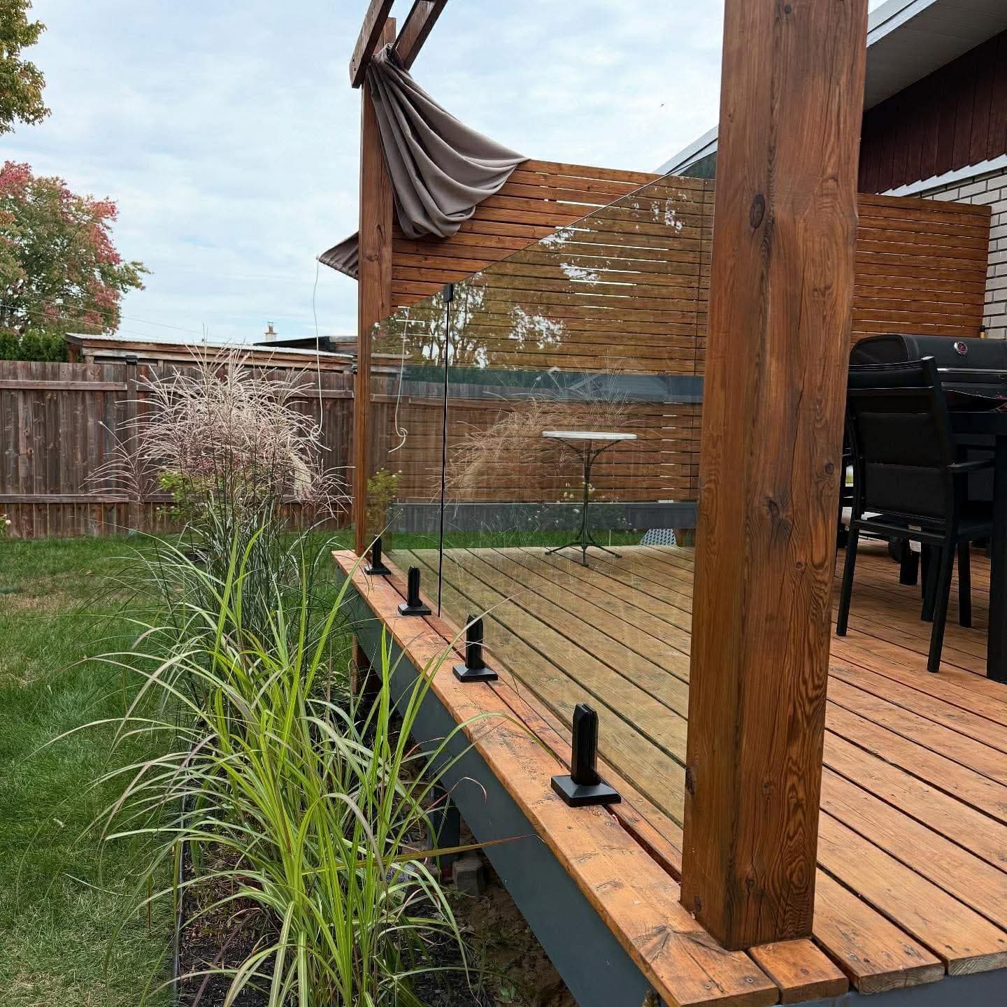 Panneaux de verre sur terrasse en bois avec pergola