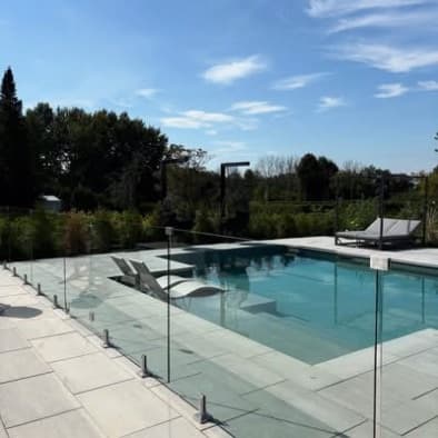 Piscine avec clôture de verre trempé, terrasse en pierre
